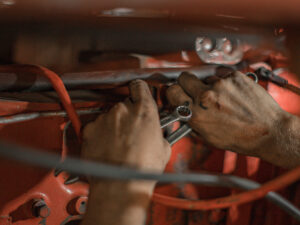 Close up of an auto mechanic’s hands working on a vehicle’s wiring