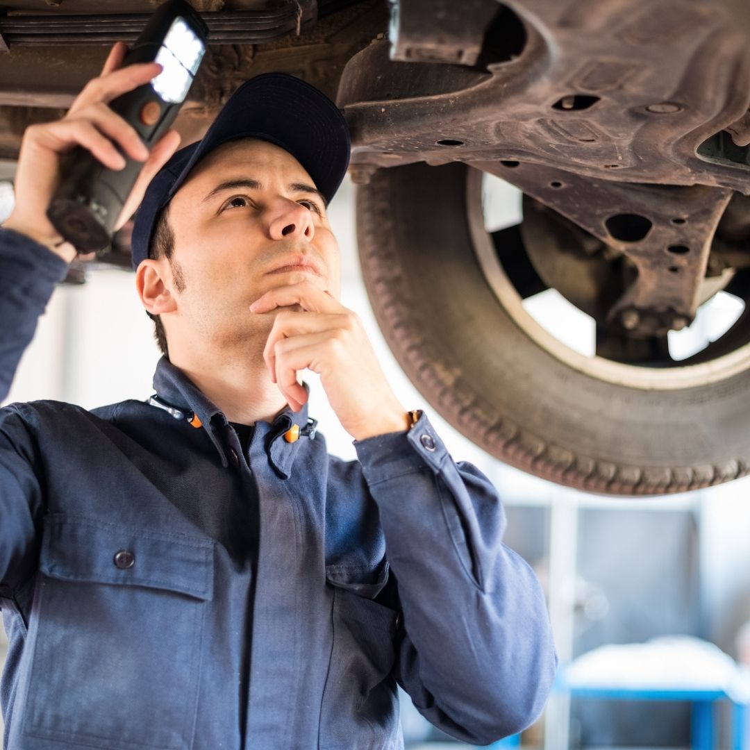mechanic looking underneath car